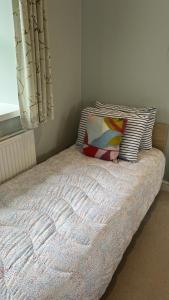 里彭Swallow Cottage的一间卧室配有一张带枕头和窗户的床