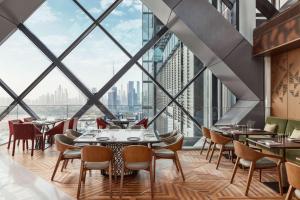 迪拜One&Only One Za'abeel的餐厅设有大窗户和桌椅