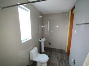 奇瓦伊Antawara的一间带白色卫生间的浴室和窗户。