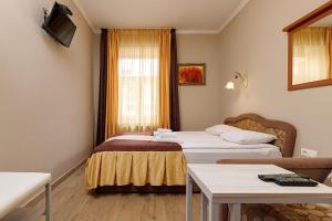 利沃夫Готель Кайзер у Львові的酒店客房设有两张床和一张桌子。