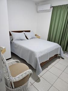 巴拉那Paraná Parque的一张床位,房间配有椅子和床筒