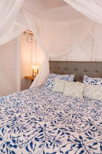 圣贝尔纳多德尔比恩托Paraíso Natural Ecohotel的一间卧室配有一张带蓝色和白色棉被的床
