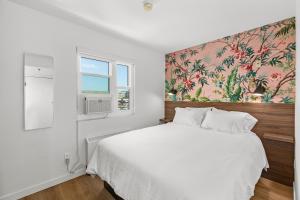 圣地亚哥Uptown Inn by Vantaggio Suites的卧室配有白色床和花卉壁纸