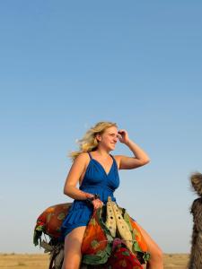 斋沙默尔Best Desert Camp In Jaisalmer Red Velvet的坐在马背上身穿蓝色衣服的女人