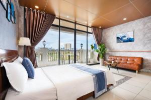 头顿CAMY Hotel Vung Tau的一间卧室设有一张大床和一个大窗户