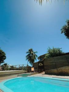 皮帕Pousada Sossego的一个带围栏和棕榈树的蓝色游泳池
