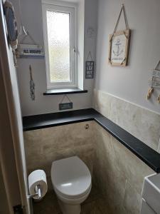 谢普顿马利特Midway的一间带白色卫生间的浴室和窗户。