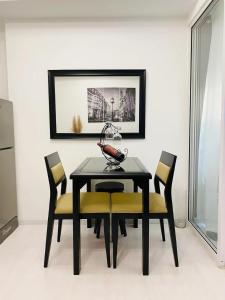 马尼拉Beach Front Living in the Heart of the City, AZURE Residences的一间用餐室,配有一张黑桌子和黄色椅子