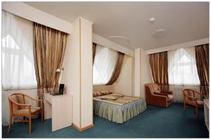 新西伯利亚科利柏酒店的酒店客房,配有一张床、一张桌子和椅子