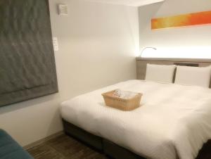 大阪斯佩里亚・大阪本町酒店的一间卧室,配有一张带篮子的床