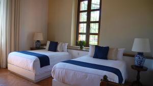 克雷塔罗Hotel Casa De Quino的带2扇窗户的客房内的2张床