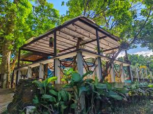 CavintiKaliraya Surf Kamp by Eco Hotel Laguna的花园中一座带屋顶的小建筑