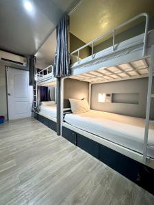 清迈八月旅舍的铺有木地板的客房内配有两张双层床。