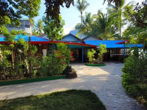 爱妮岛Hadefe Resort的一座建筑,前方有树木,屋顶蓝色
