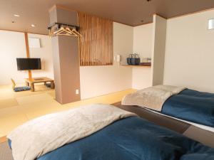 野沢长野野沢日式旅馆的一间卧室配有两张床和电视