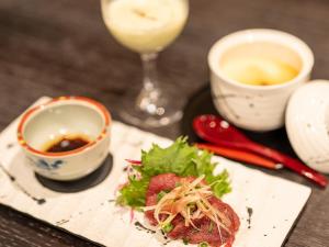 野沢长野野沢日式旅馆的一张桌子,上面放着一盘食物和一杯葡萄酒