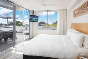 努萨角索菲特努萨太平洋度假酒店的一间卧室配有一张床,阳台配有桌子