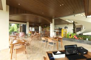 日惹Amaranta Prambanan Yogyakarta的配有木桌和椅子的餐厅以及笔记本电脑