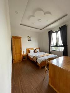 大叻HANZ Hoa Dang Hotel的一间卧室配有一张床和一张桌子