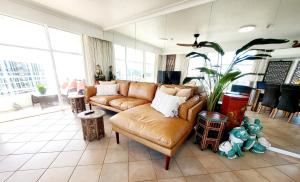 黄金海岸海滩上第19条大道酒店的客厅配有真皮沙发和植物