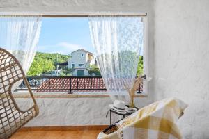罗佐瓦克Kalpic Suites & Villa的一间卧室设有窗户,享有建筑的景色