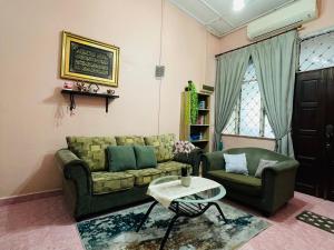 哥打巴鲁Kota Bharu Homestay的客厅配有沙发和桌子