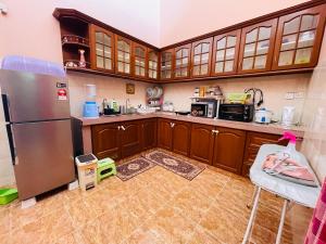 哥打巴鲁Kota Bharu Homestay的厨房配有木制橱柜和不锈钢冰箱。