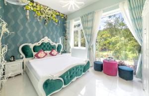 大叻Hese Dalat Boutique Resort的卧室设有绿色和白色的床和窗户。