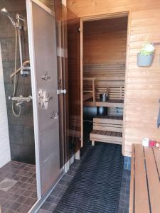 NivalaViihtyisä saunamökki päärakennuksen takana, oma rauha的一间带淋浴的浴室和一张长凳