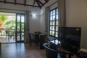 拉迪格岛圣云城堡酒店的带平面电视的客厅和阳台。