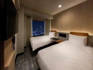 东京新宿王子大酒店的酒店客房设有两张床和窗户。