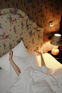 库塔伊西Communal Hotel Kutaisi的躺在床上,脚踩在枕头上的人