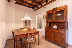 San RomanoCasa Fontana的一间带木桌和椅子的用餐室