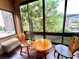 别府日本旅館　松亀荘的窗户前设有2把椅子和1张桌子的房间