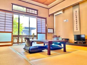 别府日本旅館　松亀荘的配有桌椅和电视的客房