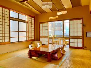 别府日本旅館　松亀荘的一间带桌椅和窗户的用餐室