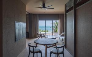宫古岛アヤンナ宮古島的一间带桌椅和海洋的客厅