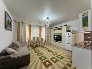 KoshkolʼRaduga West 'Pearl' Apartment的带沙发的客厅和厨房