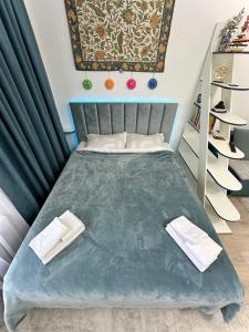 KoshkolʼRaduga West 'Azure' Apartment的一间卧室配有一张床,上面有两条毛巾