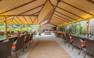 马拉里Bedzzz Xclusiv Baikunth, Manali By Leisure Hotels - 650 meters from Hidimba Devi Temple的餐厅设有木制天花板和桌椅
