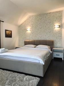 LeordinaPensiunea Sub Horiță的一间卧室配有一张带白色床单的大床