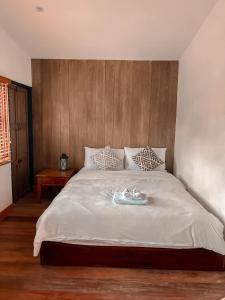 清刊The Folkster House Chiangkhan的一间卧室配有一张大床和木制床头板