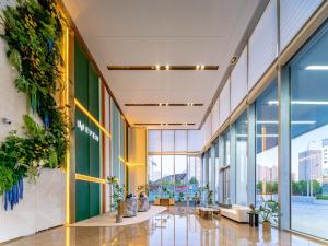 青岛青岛青铁崂山逸衡酒店的墙上有植物的建筑的大堂