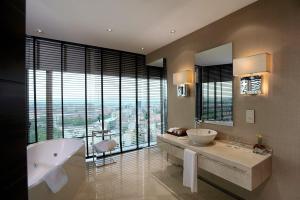 安卡拉安卡拉会议中心大酒店的一间带两个盥洗盆和浴缸的浴室以及大窗户。
