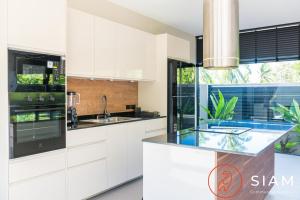 苏梅岛K-Baan Villa 2Br & Private Pool的一间厨房,配有白色的橱柜和大窗户