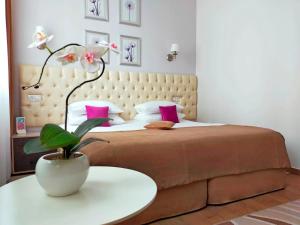 叶森图基Park & House Hotel в Курортной зоне的一间卧室配有一张大床和一张植物桌子