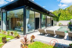 苏梅岛K-Baan Villa 2Br & Private Pool的一座带玻璃墙和游泳池的房子