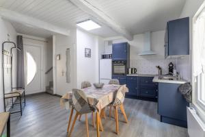 贝莱斯塔Logis Du Roussillon的厨房配有蓝色橱柜和桌椅