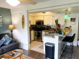 科纳ZERO FEES Aloha Lani Condo #A208 at Casa De Emdeko的厨房以及带沙发和桌子的客厅。