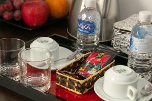 河内Hanoi Aria Central Hotel & Spa的桌子上装有玻璃杯和水瓶的托盘